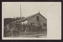 Uniformed soldiers in front of a one story building